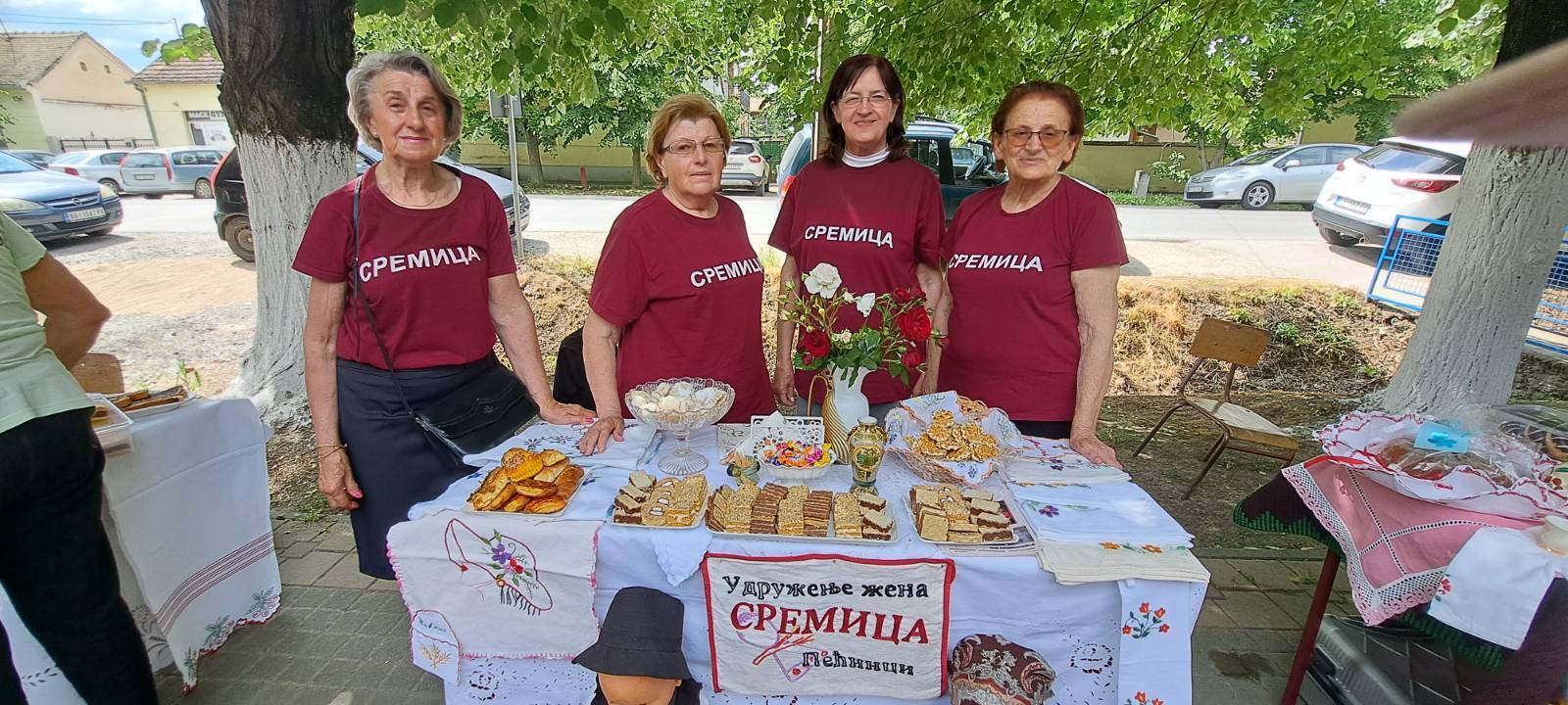 Чланице удружења Сремица на тезги са колачима и ручним радовима